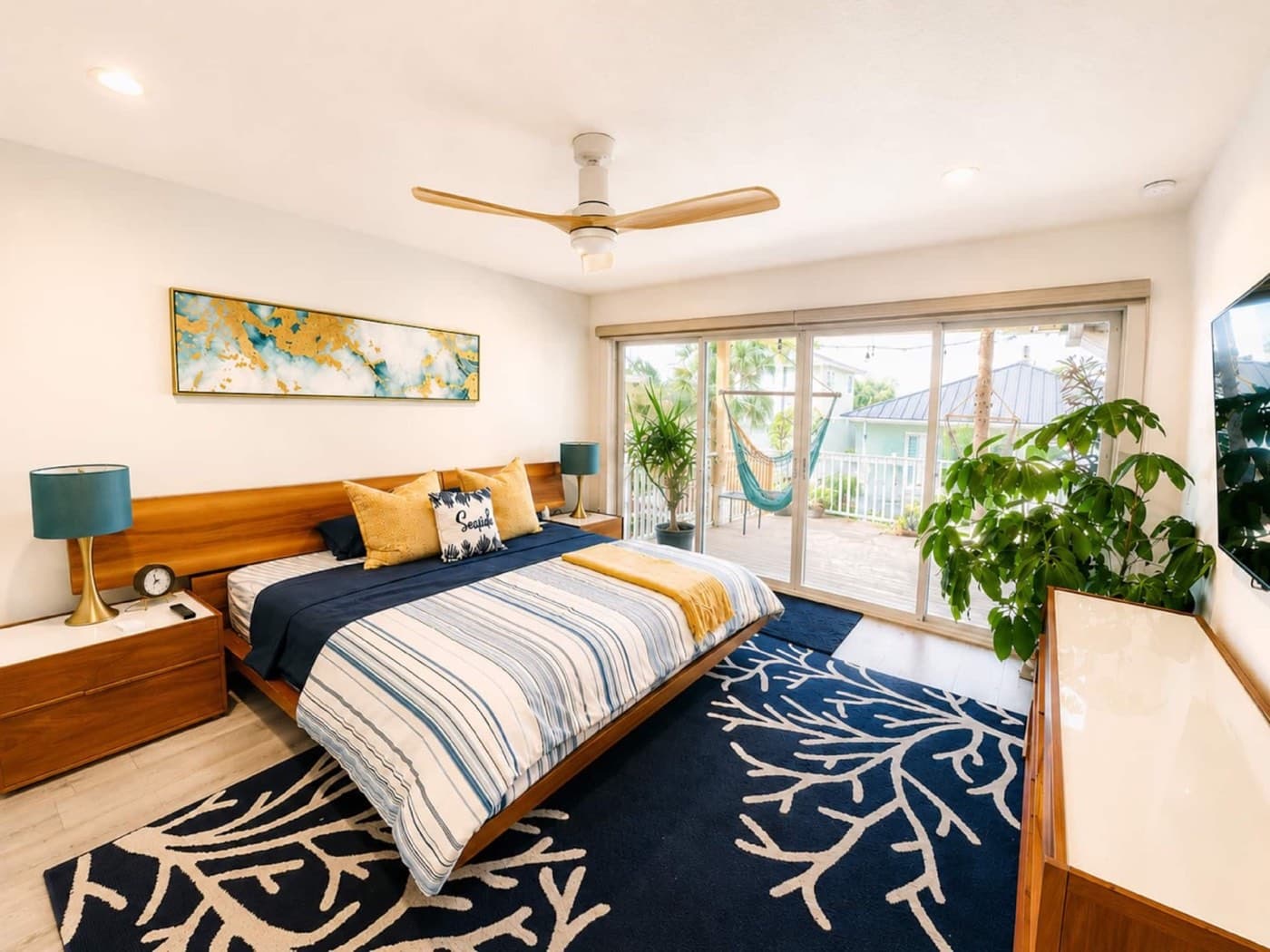 Sunny bedroom with private deck access and a relaxing hanging chair