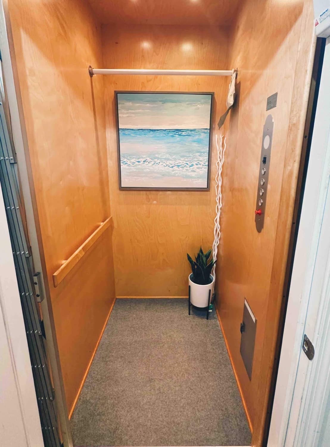 Private in-home elevator with warm wood finishes and coastal decor