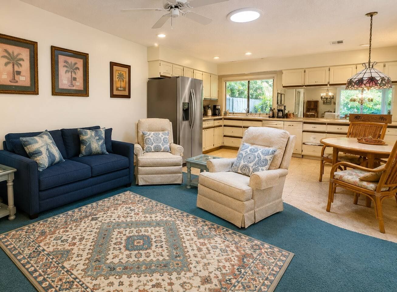 Second living area with navy loveseat and armchairs opening to the kitchen and breakfast table